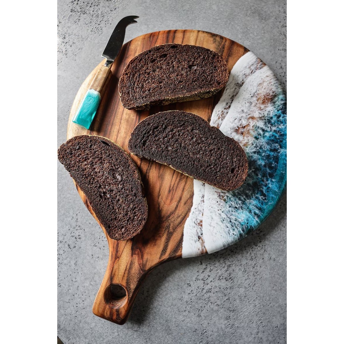 Handcrafted natural wooden chopping board with handle used for cutting meat, cheese and bread in a modern kitchen. Handcrafted natural wooden chopping board with handle used for cutting meat, cheese and bread in a modern kitchen.