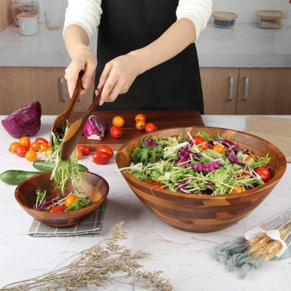 large wooden salad bowl with two wooden serving spoons