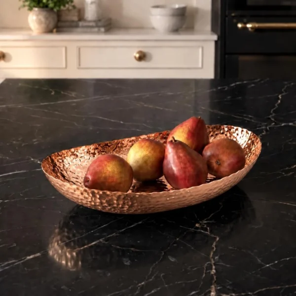 Oval hammered copper decorative bowl on wooden console