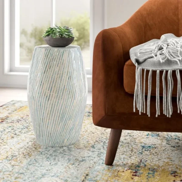 Handcrafted blue bone inlay drum side table placed beside a luxury armchair in a modern living room