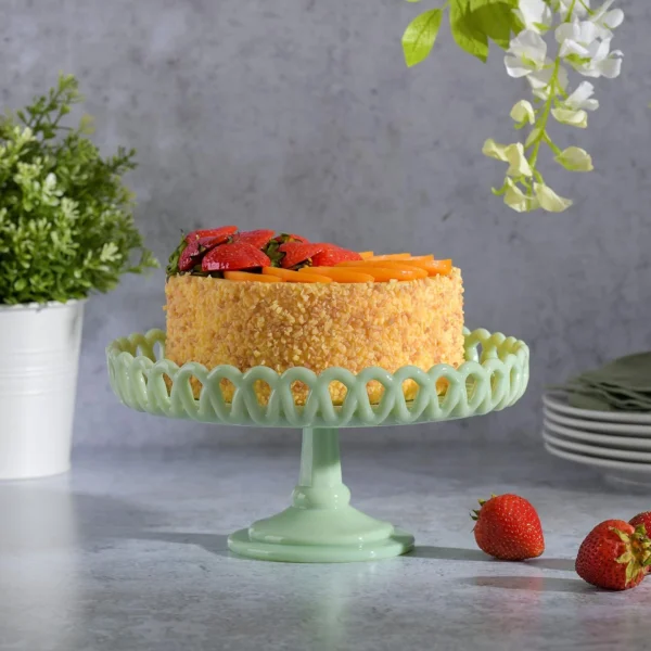 Light green decorative cake stand with raised pedestal and openwork rim