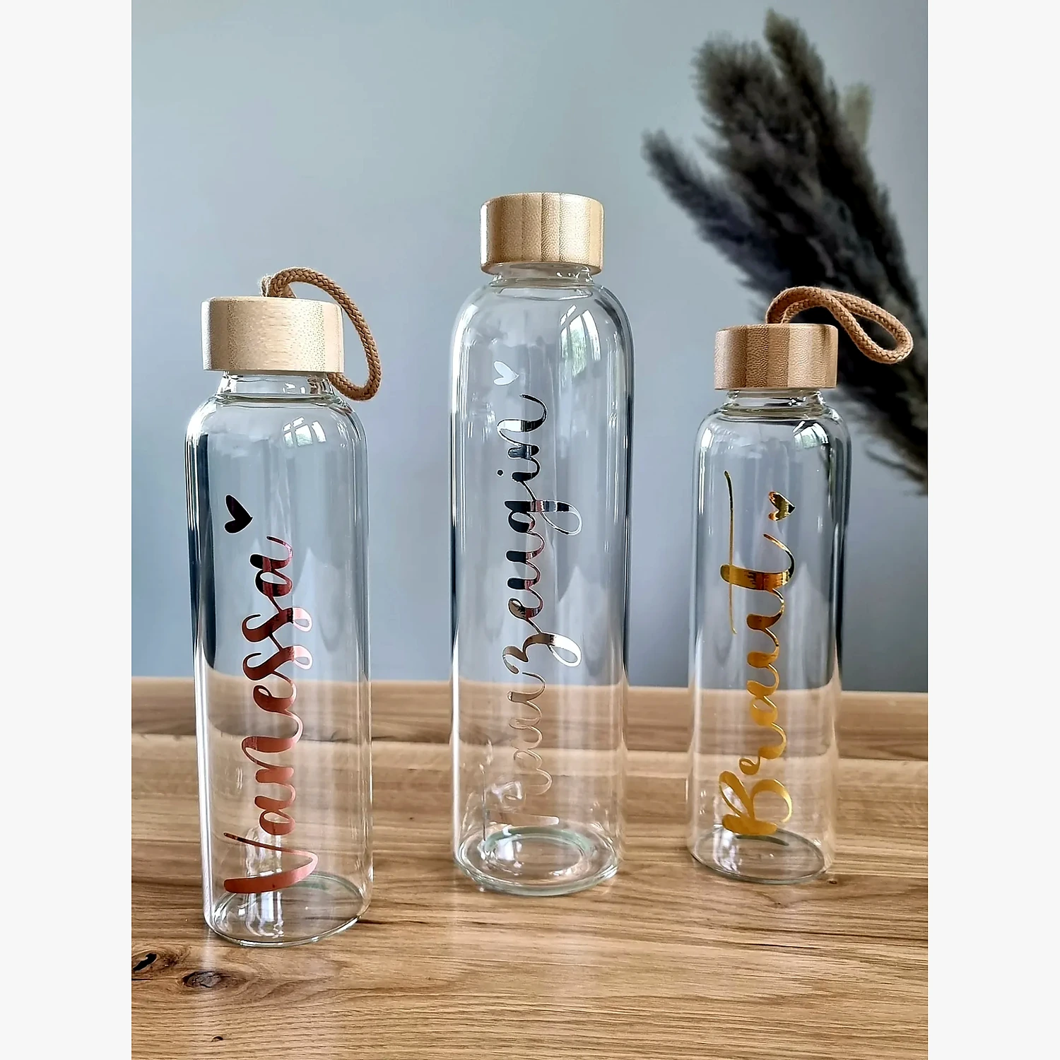 Clear glass bottle with natural bamboo cap and rope loop Clear glass bottle with natural bamboo cap and rope loop